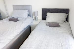 two beds sitting next to each other in a bedroom at Spacious 4 Bed, Parking, Close to Docks in Litherland