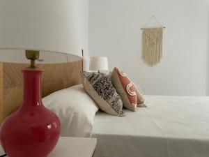 a red vase sitting on a table next to a bed at CASA MAMA CARINA in Agüimes