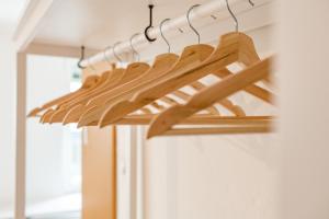a row of wooden hangers in a closet at Service Apartment direkt neben Hauptbahnhof Graz in Graz