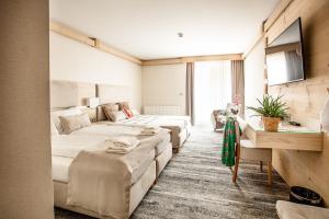 a hotel room with three beds and a desk at Villa Cannes Resort Zakopane - grota solna, sauna fińska in Zakopane