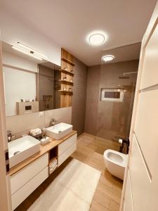 uma casa de banho com 2 lavatórios e um WC em A&Y APARTAMENT em Floreşti
