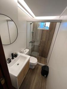 ein Badezimmer mit einem Waschbecken, einem WC und einem Spiegel in der Unterkunft La Cañada in Minas