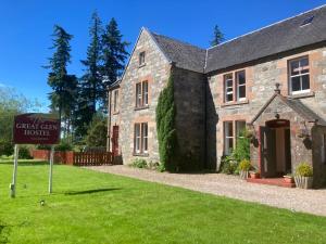 a sign in front of a stone house at Great Glen Hostel in Spean Bridge