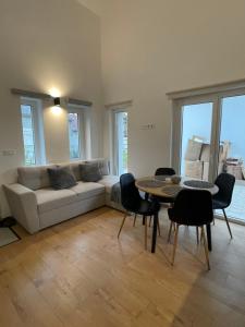 a living room with a couch and a table and chairs at Dream Apartman in Levél