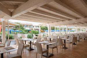 una fila de mesas y sillas en un restaurante en SECRET VILLAGE Budoni en Budoni