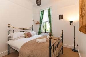 um quarto com uma cama e uma janela em Upton House - Charming 4-bedroom home in Torquay em Torquay