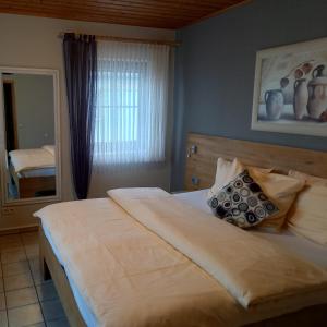 a bedroom with a large bed and a mirror at Hotel Lindenhof in Rödermark