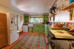 uma cozinha com armários verdes e um tapete no chão em Upton House - Charming 4-bedroom home in Torquay em Torquay