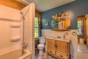 a bathroom with a toilet and a tub and a sink at Cozy Riverfront Getaway Fishing On-Site! in Lacon