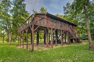 a wooden cabin in a park with trees at Cozy Riverfront Getaway Fishing On-Site! in Lacon