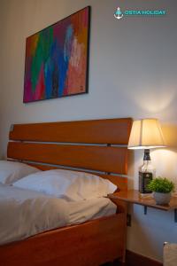 a bedroom with a bed and a table with a lamp at Appartamento Impluvium in Lido di Ostia