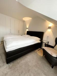 a bedroom with a large bed and a chair at Ferienwohnung am Alexbad in Bad Alexandersbad