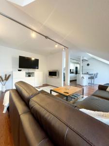 a living room with a brown couch and a table at Ferienwohnung am Alexbad in Bad Alexandersbad