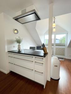 uma cozinha com armários brancos e um balcão preto em Ferienwohnung am Alexbad em Bad Alexandersbad