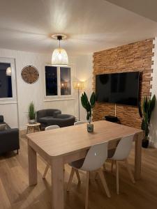 a living room with a wooden table and a tv at Le Zen - Wifi - Netflix - 3 chambres - Parking in Clermont-Ferrand