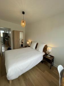 - une chambre avec un grand lit blanc et deux lampes dans l'établissement Le Zen - Wifi - Netflix - 3 chambres - Parking, à Clermont-Ferrand