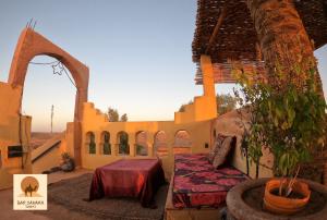 un patio avec une table et une plante dans un bâtiment dans l'établissement Auberge Kasbah Dar Sahara Tours, à M'Hamid El Ghizlane