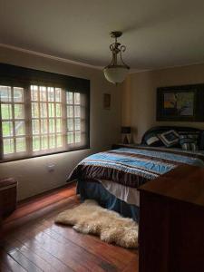 1 dormitorio con cama y alfombra en el suelo en Los Alessandria en Cerro Punta