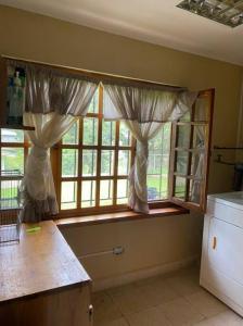 a kitchen with a window with curtains on it at Los Alessandria in Cerro Punta