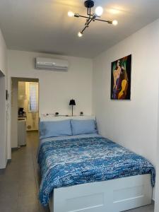 a bedroom with a bed with a blue comforter at Daisy House in Ferrara