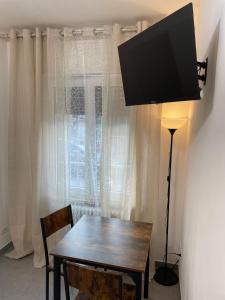 ein Esszimmer mit einem Tisch und einem TV an der Wand in der Unterkunft Daisy House in Ferrara