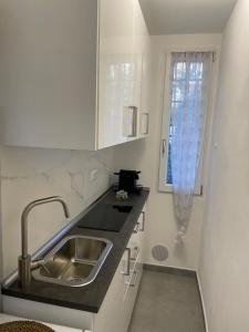 eine kleine Küche mit einem Waschbecken und einem Fenster in der Unterkunft Daisy House in Ferrara