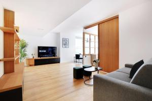 a living room with a couch and a tv at Superbe Appartement - Père Lachaise in Paris