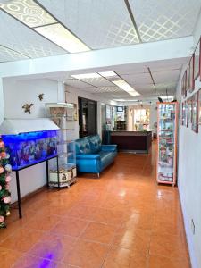 a room with a blue couch and a fish tank at Hotel Mi Casita Pereira in Pereira