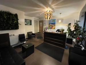 uma sala de estar com um sofá e cadeiras e um lustre em A&C Hotel em Backnang