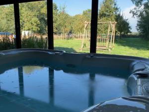 a hot tub with a view of a playground at De Porrel Polsbroek Unit met Privé Jacuzzi, Spa en Sauna in Polsbroek