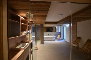 un bagno con un lavandino e una vasca in una stanza di Tanners Chalet Apartments a Altenmarkt im Pongau Altre 72 foto