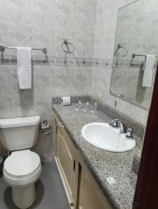 uma casa de banho com um WC branco e um lavatório. em OCEANIk SUITES & HOTEL em Guayaquil