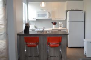 a kitchen with a sink and a white refrigerator at Le Chic-Urbain in Rouyn-Noranda