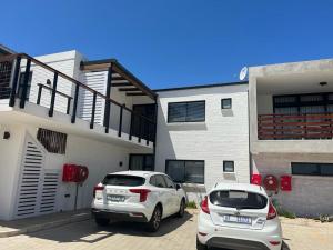 two cars parked in a parking lot in front of a building at Kabeljauws Beach Estate in Jeffreys Bay +8 photos