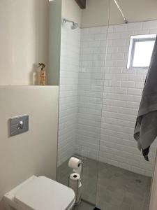 a bathroom with a toilet and a glass shower at Kabeljauws Beach Estate in Jeffreys Bay