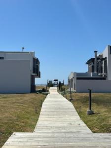 a wooden walkway leading to a building on a field at Kabeljauws Beach Estate in Jeffreys Bay