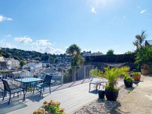 eine Holzterrasse mit einem Tisch und Stühlen auf dem Balkon in der Unterkunft Ockendon House Apartments in Torquay