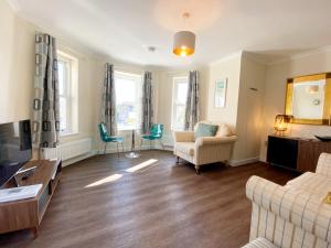 a living room with a couch and chairs at Ockendon House Apartments in Torquay