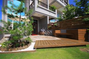 un giardino con panca in legno di fronte a un edificio di Zhileju Homestay a Città di Hualien