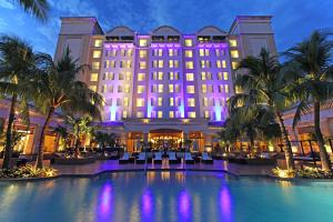 a hotel with a pool and palm trees at night at Real Intercontinental Metrocentro Managua, an IHG Hotel in Managua