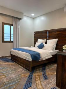 um quarto com uma cama grande e uma cabeceira em madeira em Elaf Al Sharqyah Hotel فندق ايلاف الشرقية em Al Khobar