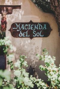 una señal en el lado de un edificio con plantas en Hacienda Del Sol, en Taos