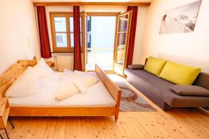a living room with a bed and a couch and a window at das Cityhouse in Mayrhofen +19 photos