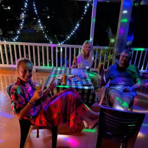 grupa ludzi siedzących przy stole z drinkami w obiekcie Kandy City Village w mieście Kandy
