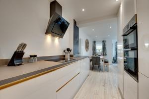 a kitchen with white cabinets and a counter top at Staithes House by Week2Week in Low Team