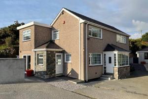 a brick house with white doors on a street at Rhoslan. Boutique style farmhouse in Snowdonia in Caernarfon