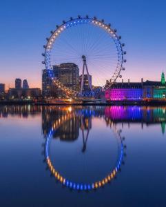 a ferris wheel with lights in the water at night at Cool Place 02 Academy in London