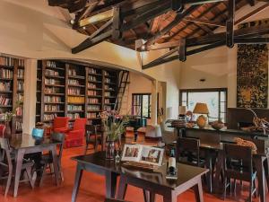 a library with tables and chairs and bookshelves at Reserva Natural Iguazú - Posada Puerto Bemberg in Puerto Libertad