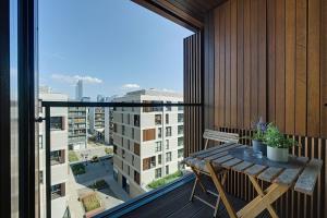a balcony with a table and a view of a city at GO Apartments in Warsaw