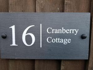 ein Schild auf einem Holzzaun, der Cranberry Cottage liest in der Unterkunft Cranberry Cottage in Wallingford